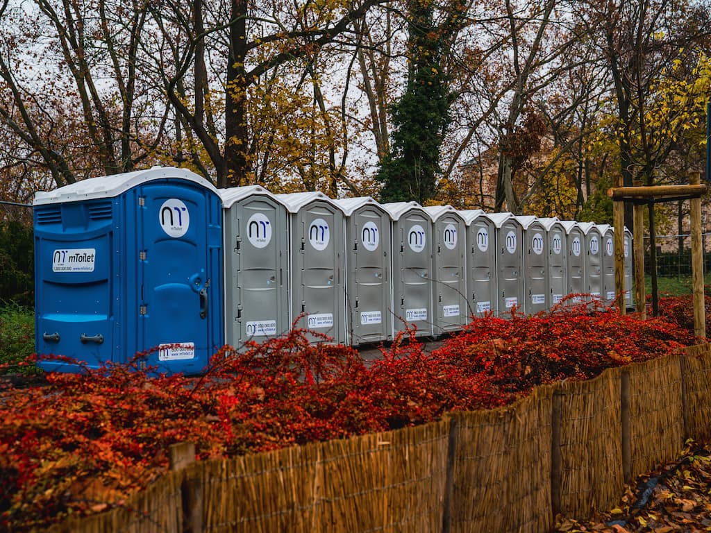 Eine Reihe mobiler Toiletten in einem Park